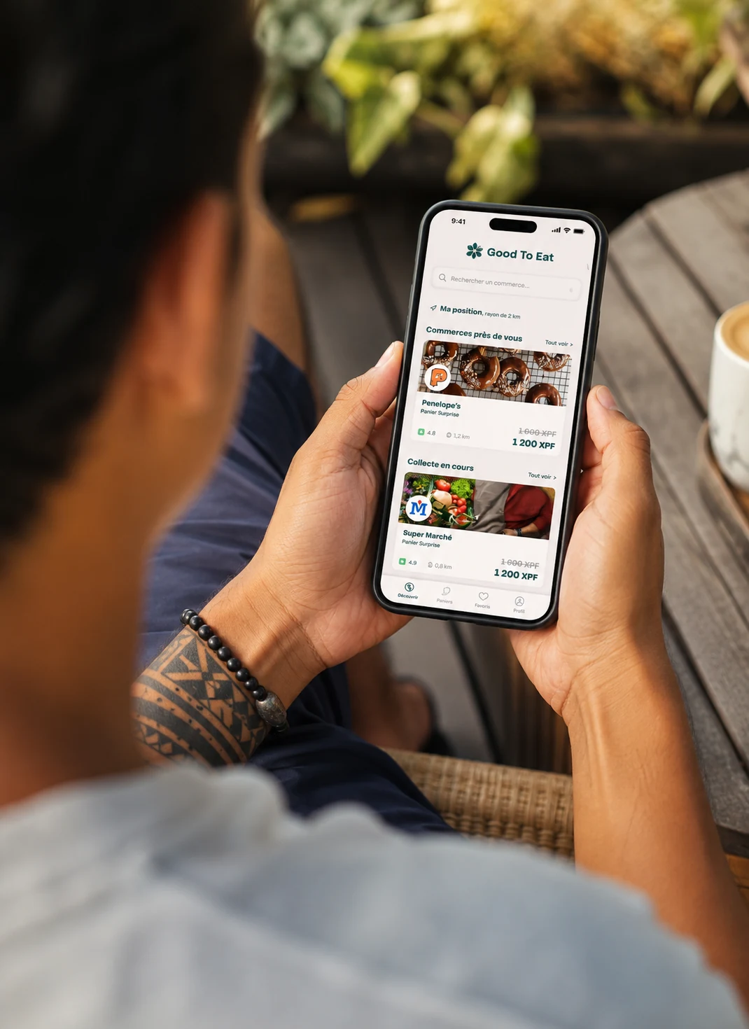 Un téléphone tenu en main, l’app ouverte sur la carte, en extérieur.
